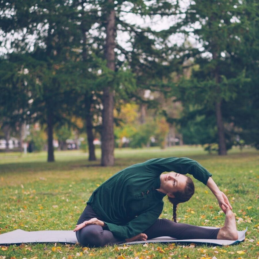 Woman stretching on yoga mat in park